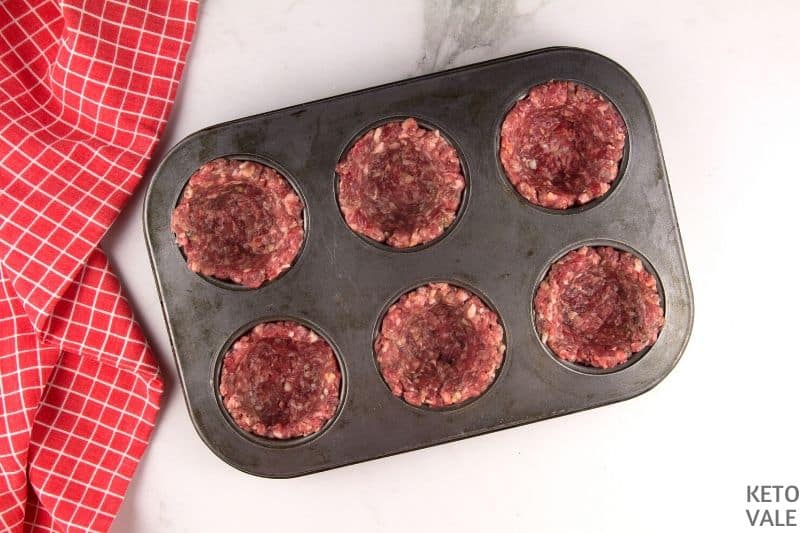 put sausage patty in muffin tin