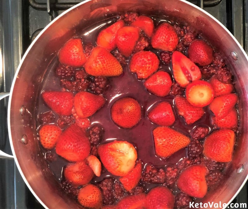 Cook strawberries, blackberries, and stevia