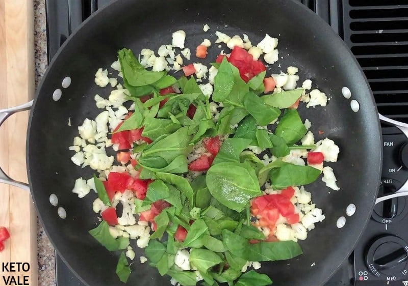 Saute cauliflower, spinach, tomatoes in butter